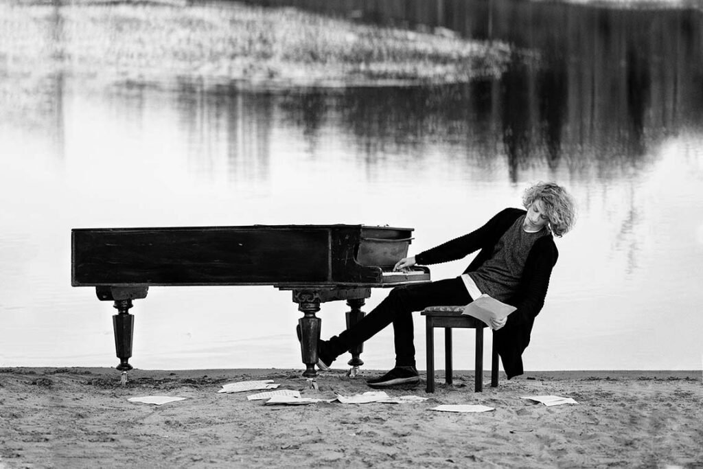 a la orilla de un lago hombre tocando el piano